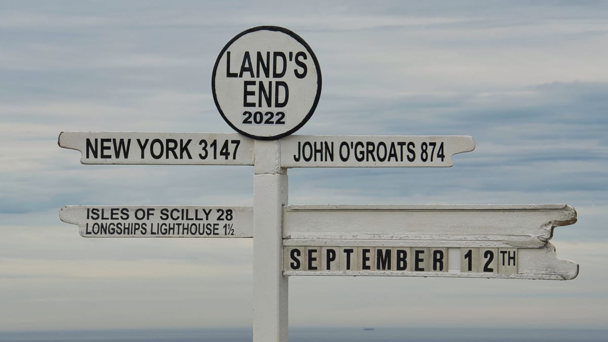 A signpost with multiple directional arrows against a bright sky.